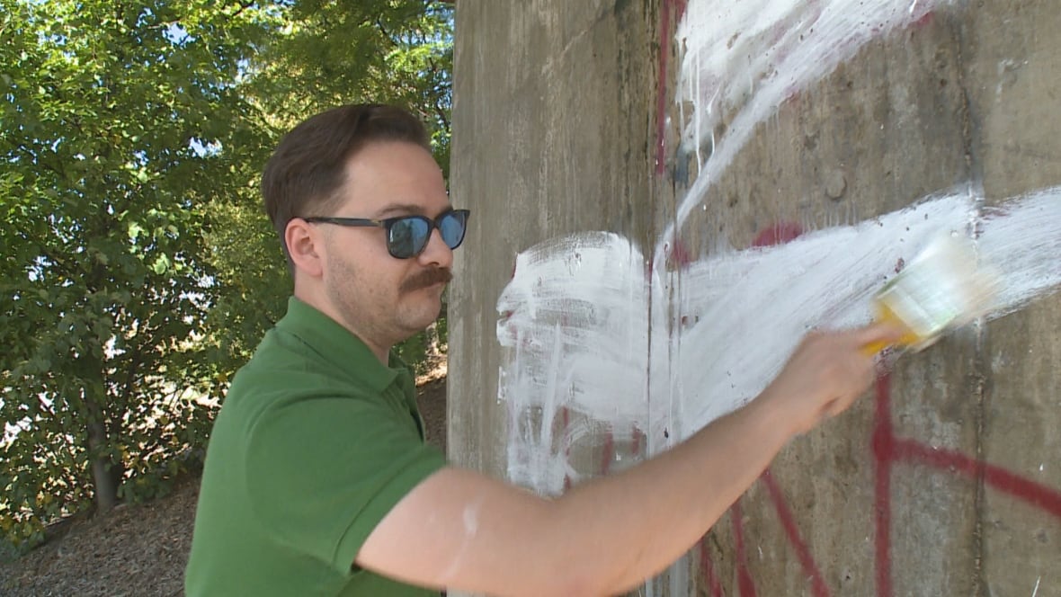 Jon Liedtke drove around the city Sunday afternoon painting over top messages that read "Islam means surrender." (Melissa Nakhavoly/CBC News)