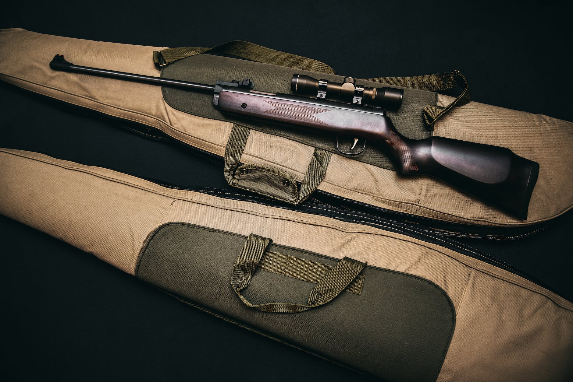 black rifle with scope and brown gig bag (Photo by Alex Andrews)
