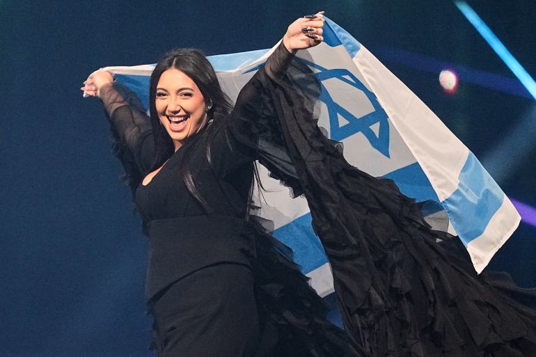 Israeli singer Yuval Raphael holds the Israeli flag during dress rehearsal at 69th Eurovision Song Contest, May 16, 2025, in Basel, Switzerland. (Martin Meissner/AP Photo)